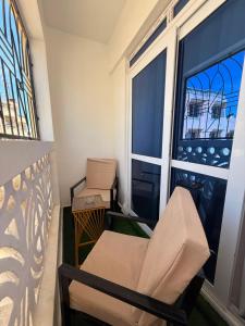 a balcony with a chair and a large window at Coastal comfort studio apartment in Mombasa