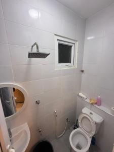 a bathroom with a toilet and a sink and a mirror at Coastal comfort studio apartment in Mombasa