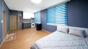a bedroom with a bed and a kitchen at Yeosu Trip Pension in Yeosu