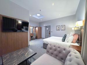 ein Hotelzimmer mit Bett und Fernseher in der Unterkunft The Yorkshire in Harrogate
