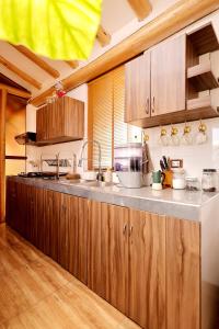 a kitchen with wooden cabinets and a sink at Arins House in Cusco +35 photos