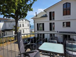 a balcony with chairs and a table and a building at Ferienwohnung Feuerstein in Sassnitz