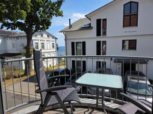 a table and chairs on the balcony of a house at Ferienwohnung Feuerstein in Sassnitz