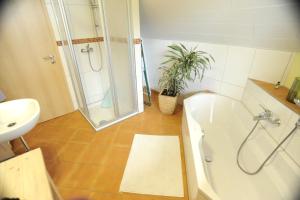 Un baño con ducha, bañera y lavabo. en Haus Grabenbühl, en Wieden 24 fotos más