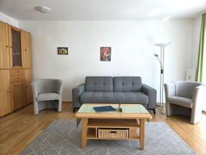 a living room with a couch and two chairs at Ferienwohnung Feuerstein in Sassnitz +5 photos