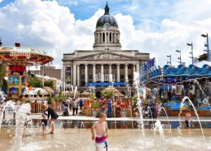 a group of children playing in a fountain in front of a building at The Peaceful Home in Nottingham +7 photos
