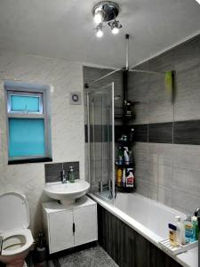 a bathroom with a sink and a toilet and a shower at The Peaceful Home in Nottingham