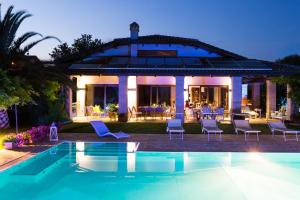 a villa with a swimming pool in front of a house at Villa Sara in San Costanzo