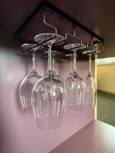 four wine glasses hanging from a rack on a wall at Wohnen an der Mühlenwiese in Bad Sobernheim