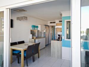 a kitchen and dining room with a table and chairs at Appartement Cap Hermès in Fréjus
