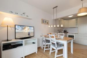 a kitchen and dining room with a table and a television at Ferienwohnung "Ostseewind" - Bade- & Saunawelt täglich inklusive in Göhren