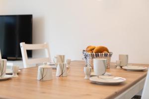 a wooden table with plates and a basket of food at Ferienwohnung "Ostseewind" - Bade- & Saunawelt täglich inklusive in Göhren