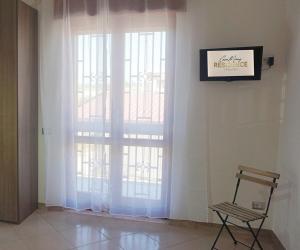 a room with two large windows with white curtains at CasaMamy Residence in Pompei