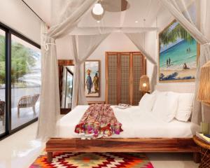 a bedroom with a white bed with a canopy at Cocco Lagoon Resort & SPA 