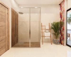 a shower with a glass door in a bathroom at Cocco Lagoon Resort & SPA 