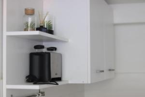 a kitchen with white shelves and a television at MaRuLiving M71 EG in Cologne