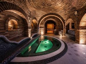 an indoor swimming pool in a building with a brick wall at Nánaháza in Alsónána