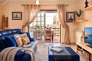 a living room with a blue couch and a tv at Ericeira Sunset Lifestyle I in Ericeira