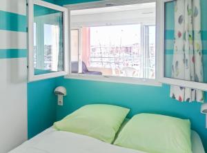a bedroom with blue walls and a bed with a window at Appartement Cap Hermès in Fréjus +126 photos