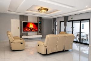 a living room with two chairs and a fireplace at Brooke Paradise in Bulawayo
