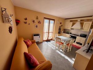 a living room with a yellow couch and a table at Appartamento Orchidea in Lepreno