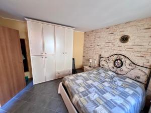 a bedroom with a bed and a brick wall at Appartamento Orchidea in Lepreno