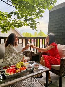 two women sitting on a porch with a table of food at La Suite du Havre in Saint-Charles-des-Grondines +16 photos