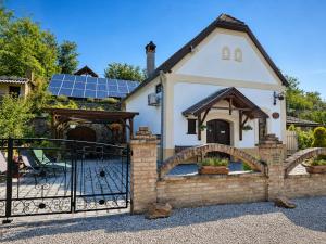 a house with a gate and a house with solar panels at Nánaháza in Alsónána