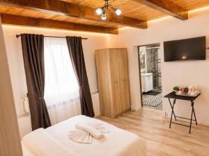 a bedroom with a bed and a table and a television at Casa Aida in Peşteana