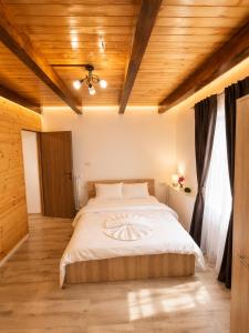 a large bed in a room with a wooden ceiling at Casa Aida in Peşteana