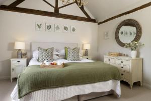 a bedroom with a bed with a tray of fruit on it at Perry Cottage in Halford