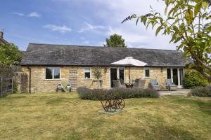 a stone house with a table and chairs in the yard at Perry Cottage in Halford