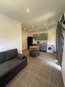 a living room with a couch and a kitchen at Chalet Jean Leclaire in Sarlat-la-Canéda