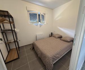 a small bedroom with a bed and a window at Chalet Jean Leclaire in Sarlat-la-Canéda