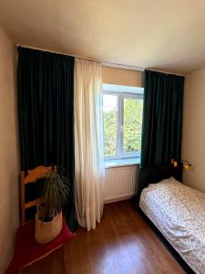 a bedroom with a bed and a large window at Tbilisi Vake Inn in Tbilisi City