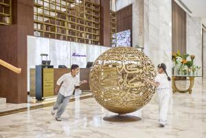 a man and a woman standing next to a large sculpture at Makarem Ajyad Makkah Hotel in Mecca