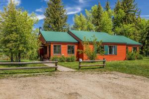 a cabin in the woods with a green roof at Riverhouse in Clark