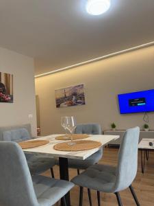 a dining room with a table and chairs and a tv at Almare ApartHotel in Golem