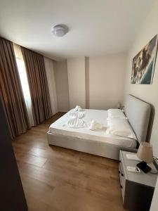 a bedroom with a large white bed and a desk at Almare ApartHotel in Golem