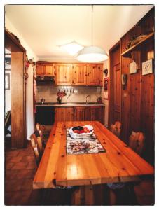 een keuken met een houten tafel en een fruitschaal bij Casa Mizzau in Camporosso in Valcanale