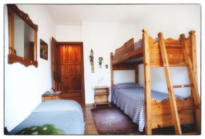 ein Schlafzimmer mit einem Etagenbett mit einer Leiter in der Unterkunft Casa Mizzau in Camporosso in Valcanale
