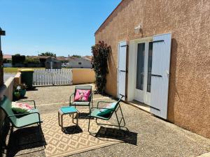a group of chairs sitting next to a building at La Fleur des Marais - Maison tout confort au calme, grand jardin & balançoire in Le Château-dʼOléron