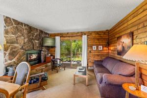 a living room with a couch and a stone wall at Wood Duck in Clark