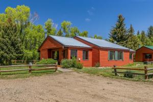 a log cabin with a fence in front of it at Wood Duck in Clark