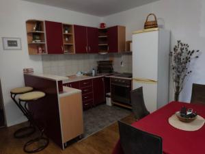 a kitchen with red cabinets and a table and a refrigerator at My Way in Beograd +7 photos