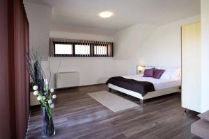 a bedroom with a bed and a vase of flowers at Szalóki Üdülőház in Egerszalók