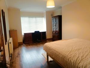 a bedroom with a bed and a dresser and a window at Ideal Guest Home in Waterford