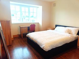 a bedroom with a bed and a desk and a window at Ideal Guest Home in Waterford +2 photos