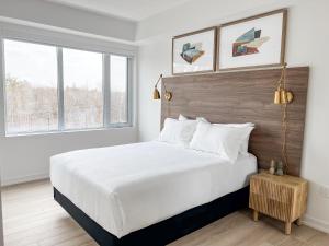 a white bedroom with a large bed and two windows at Muskoka Bay Resort in Gravenhurst +73 photos