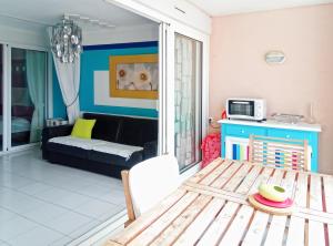 a living room with a table and a couch at Appartement Cap Hermès in Fréjus